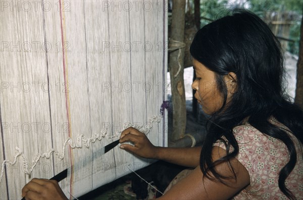 COLOMBIA, Sierra de Perija, Yuko-Motilon, Girl weaving cotton “manta”  / cloak at a Yuko - Motilon household loom in village near  the Colombian-Venezuelan frontier