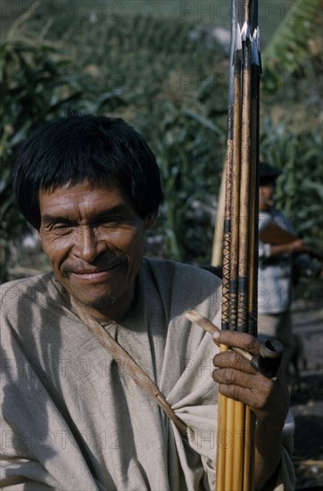 COLOMBIA, Sierra de Perija, Yuko - Motilon ., "Man clutching hardwood bow and quiver of steel-headed arrows for mammals and birds, clay pipe for tobacco, wearing woven cotton “manta”  / cloak."