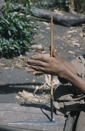 COLOMBIA, Sierra de Perija, Yuko - Motilon ., Man drills hole in base of steel arrow-head for attachment to bamboo shaft