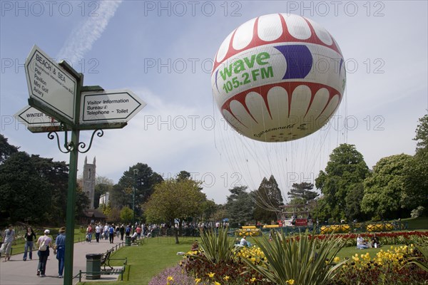 ENGLAND, Dorset, Bournemouth, The Bournemouth Eye balloon lifting off in The Upper Pleasure Gardens with tourists on the grass and the pathways