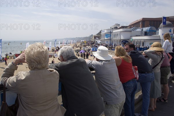 ENGLAND, Dorset, Bournemouth, Tourists watching speedboat races off the West Beach with the Oceanarium and BICC Bournemouth International Conference Centre on the right