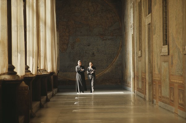 ITALY, Lazio, Rome, Vatican City.  Clerics in discussion walking along loggia beside Secretariat of State.