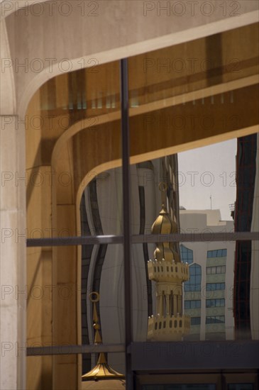 UAE, Abu Dhabi, Arabian Monetary Fund Head Office building. Detail of windows with minarets and tall buildings reflected in the glass