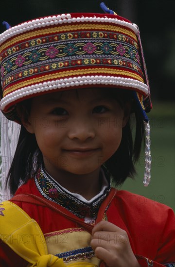 CHINA, Yunnan, "Near Kunming. Portrait of a young Sani girl at the Stone Forest, wearing a decorated hat with bead trim."