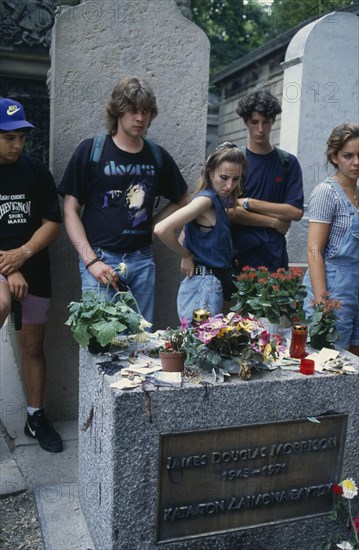 FRANCE, Ile de France, Paris, Pere Lachaise Cemetery. Visitors surrounding Jim Morrison’s Grave