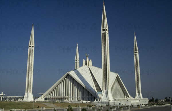 PAKISTAN, Islamabad, "Shah Faisal mosque.  Designed by Vedat Dalokay, construction completed 1986.  White exterior with pyramidal roof and four minarets."