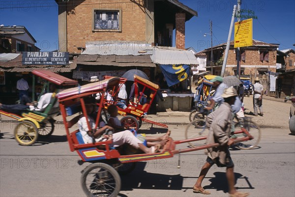 MADAGASCAR, Antsirabe, Rickshaws with passengers traveling along road