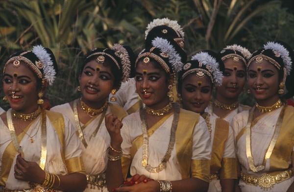 INDIA, Kerala, Thiruvananthapuram, "Mohiniyattam dancers at The Great Elephant March festival. A group of young girls with hair decoration, gold jewellery, earrings and nose rings."
