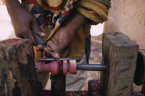 MADAGASCAR, Ambositra, Close up of the hands of an Artisan carving a piece of rosewood