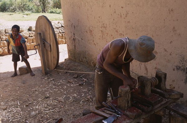 MADAGASCAR, Ambositra,  Artisan carving rosewood using child powered lathe