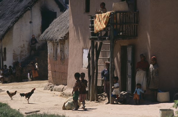 MADAGASCAR, People, Road to Ranomanfana. Women and children in village with thatched huts and cockerels roaming freely