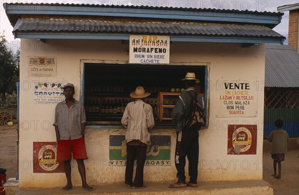 MADAGASCAR, Ihosy, Men standing at a kiosk which sells rum and beer