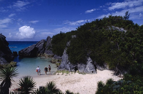 BERMUDA, Jobsons Cove, People in secluded cove with sand beach and seawater pool almost encircled by eroded rocks and vegetation.