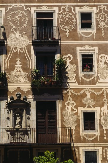 SPAIN, Catalonia, Barcelona, Decorated exterior of flats on the Plaza Delfi with potted plants and flowers on the balconies and window sills.