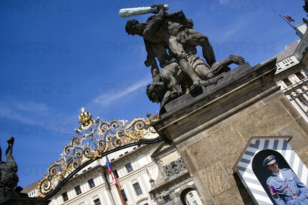 CZECH REPUBLIC, Bohemia, Prague, The entrance to Prague Castle in Hradcany with a sentry standing guard beneath an 18th Century statue of fighting giants by Ignaz Platzer