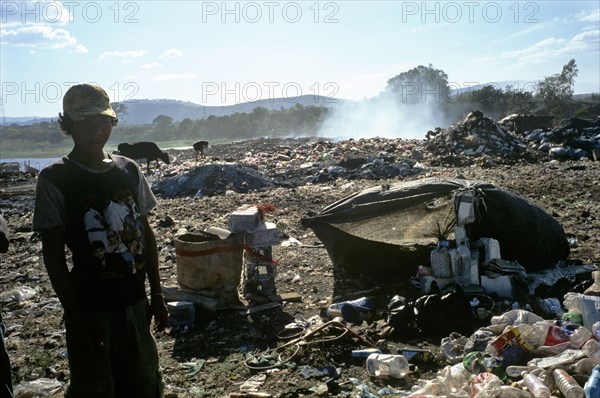 NICARAGUA, Managua Province, Managua, "The 'waste basket of Chureca' has existed since the late 1960's in the Acahualinca district of Managua, Nicaragua. It covers 42 hectares, is bombarded with thousands of tonnes of waste a day and is home to over 170 struggling families. By day over 1500 more Nicaraguans arrive at the site, some of whom are children who have been sent by their parents, others come by their own initiative. All compete with the adults to find, harvest and re-sell recyclable material. Of the minors who go to the waste basket - 88% it has respiratory problems, 62% suffer from parasites and 42% have serious skin diseases. Although the sky is clear and blue the air is thick of burning waste or rotting waste. Little houses or 'casitas' lie in a mixed muddle of rubbish and waste. The houses at the back of shot are made up of an eclectic collection of doors, wooden planks, dustbin bags, hanging bits of ripped tarpaulin, corrugated iron strips and whatever waste material seem...