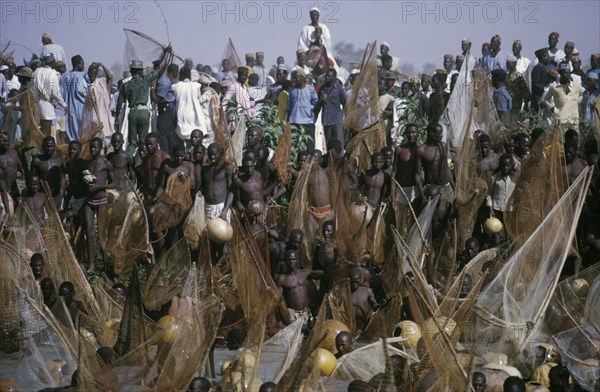 NIGERIA, North, Argungu, Crowds of spectators and competitors in annual three day fishing festival in which giwan ruwa fish are caught with hand nets and calabashes.