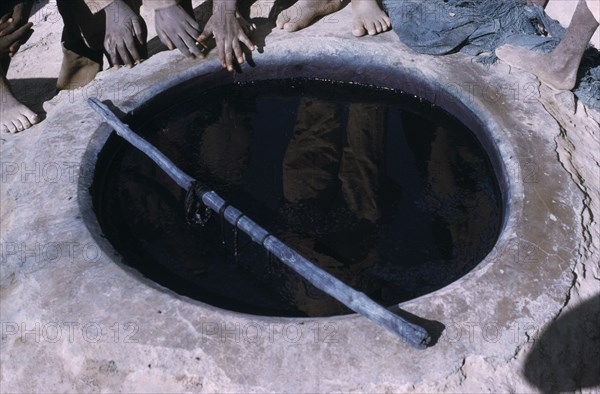 NIGERIA, Katsina, Indigo dye pit reflecting workers.