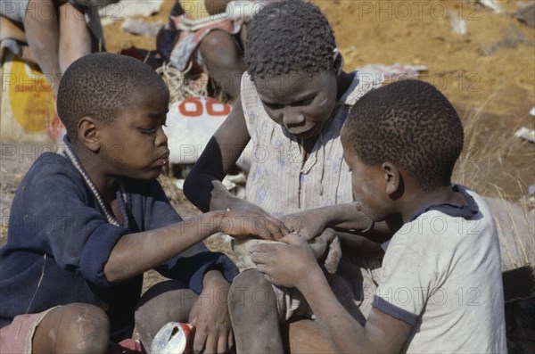 SOUTH AFRICA, Gauteng, Soweto, Three children eating from rubbish dump.