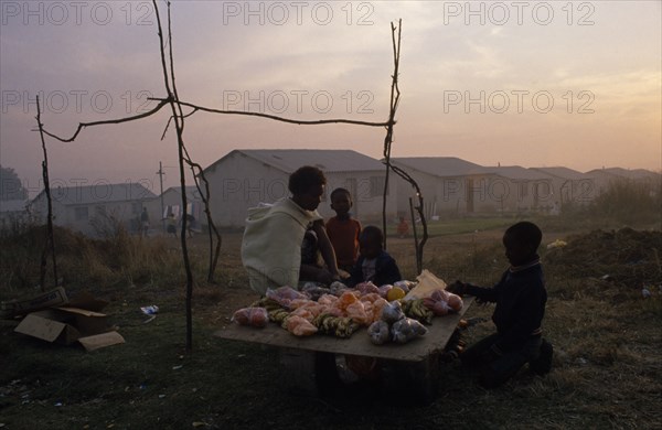 SOUTH AFRICA, Eastern Cape, Port Elizabeth, Women and children selling fruit from makeshift stall in township.