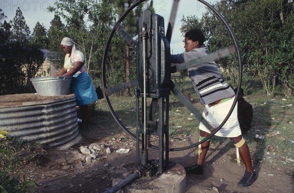 SOUTH AFRICA, Kwazulu Natal, Women drawing water for washing at well.