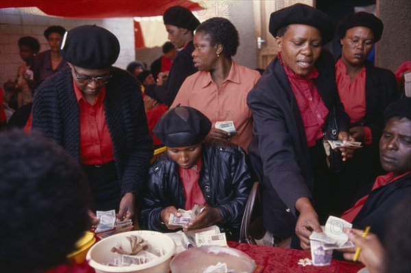SOUTH AFRICA, Gauteng, Alexandra Township, "Female members of Burial Society or Stokvel counting money.  Funerals are seen as an important part of culture and tradition and are costly, often lasting several days."