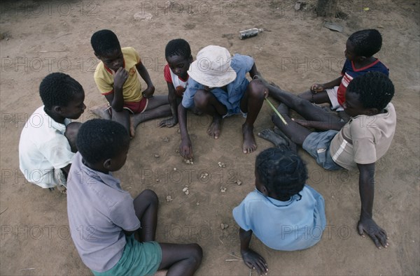 ZIMBABWE, People, Children playing mancala game of bao using stones and depressions in ground rather than board and counters.
