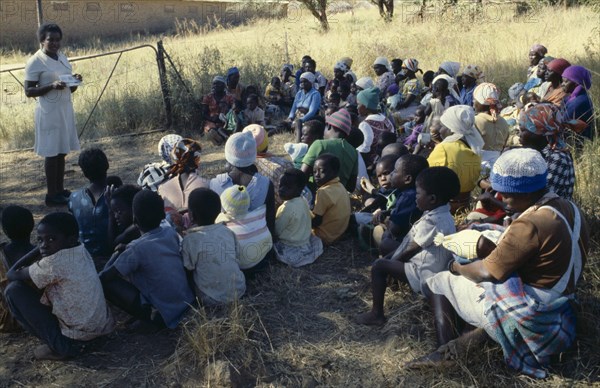 ZIMBABWE, People, Family Planning Association education officer and distributor talking to women on farming compound.