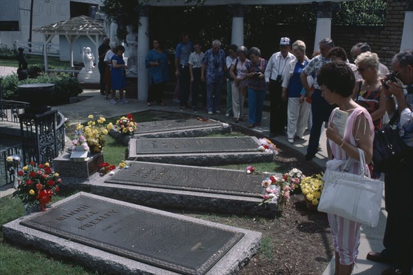 USA, Tennessee, Memphis, Graceland. Home of  Elvis Presley. Visitors at the graves of members of the Presley family