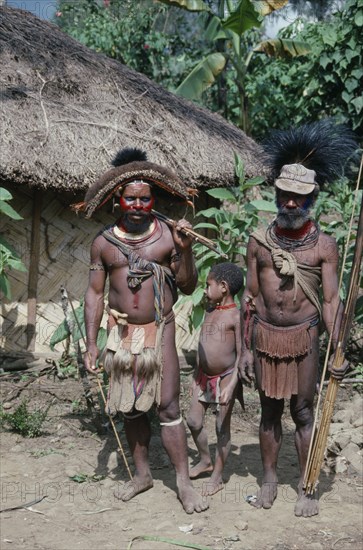 PACIFIC ISLANDS, Melanesia, Papua New Guinea, Southern Highlands.Tari. Huli tribemen with a child holding cane