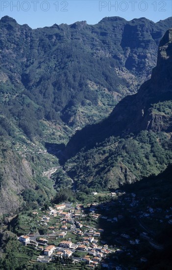 PORTUGAL, Madeira, Camara de Lobos, Curral das Freiras. View over the valley with partially forested mountains encircling the village