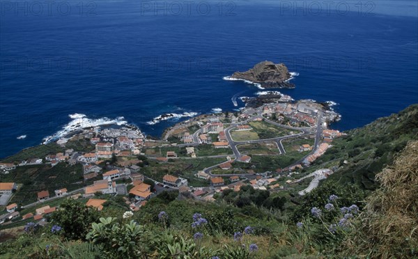 PORTUGAL, Madeira, Elevated view from the north coastal road over Porto do Moniz rooftops and coastline