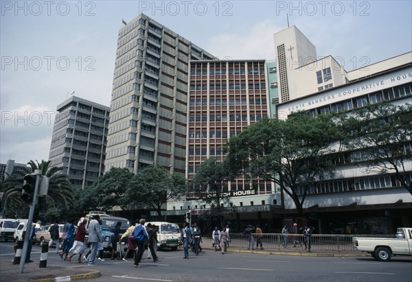 KENYA, Nairobi, "Downtown Nairobi with people crossing road, waiting traffic and high rise buildings."