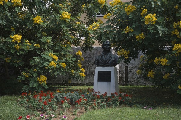 BERMUDA, St George, Bust of Irish Poet Thomas Moore who visited Bermuda in 1804 surrounded by yellow flowering bushes.