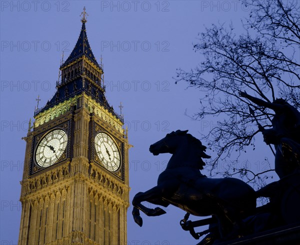 ENGLAND, London, Westminster.Big Ben Clock Tower and the statue of Boudicea in silhouette in the foreground seen in evening light