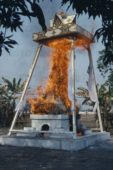 LAOS, Vientiane, Funeral Pyre engulfed in flames at a Buddhist cremation.