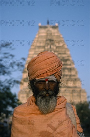 INDIA, Karnataka, Hampi, Holy man in front of Virupaksha Temple in the ancient city of Vijayanagar