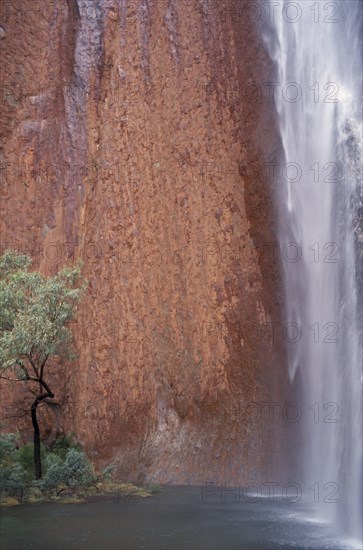 AUSTRALIA, Northern, Uluru, Ayers Rock. Maggie Springs. Cascading waterfall after torrential rainfall of 69mm in forty eight hours. An event that only happens once in every four years
