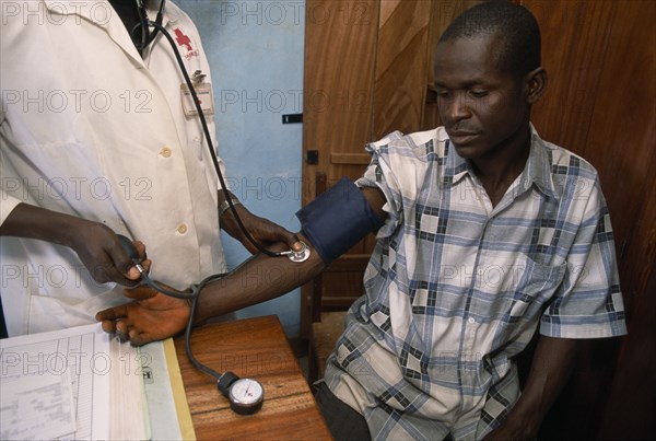 GUINEA, Kissidougou Camp, Man in refugee camp for Sierra Leonean  refugees having his blood pressure taken in the camp clinic.