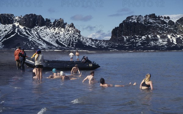 ANTARCTICA, Peninsula Region, Deception Island, Tourists swimming in geothermally heated water which is considered an active volcano