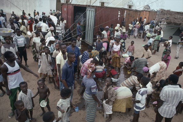 LIBERIA, War, People displaced by civil war attempting to recover cooking oil spilt in queue for UN food aid.