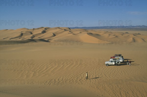 LIBYA, Sahara Desert, Tourists with four by four vehicles in desert landscape.