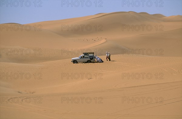 LIBYA, Sahara Desert, Tourists four by four vehicle stuck in Saharan sand.