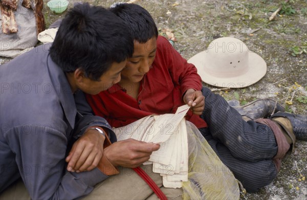 TIBET, People, Reading Tibetan prayer book.