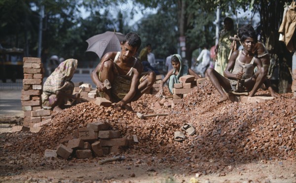 BANGLADESH, Dhaka, Men and women stone breaking with bricks and hammers