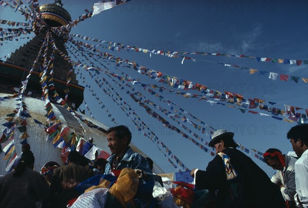 NEPAL, Kathmandu, Bodhanth Stupa, Tibetans hanging the stupa with prayer flags for new year celebrations.