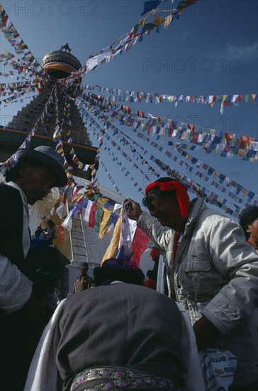 NEPAL, Kathmandu, Bodhanth Stupa, Tibetans hanging stupa with prayer flags during new year celebrations.