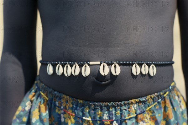 SUDAN, Tribal People, Cropped shot of Dinka girl wearing cowrie shell belt to indicate puberty.