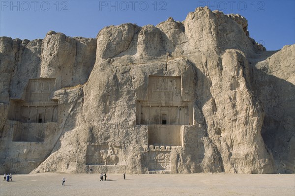 IRAN, Fars Province, Naghshe Rostam , Naghshe Rostam near Persepolis. Achaemenian Tombs with visitors walking around
