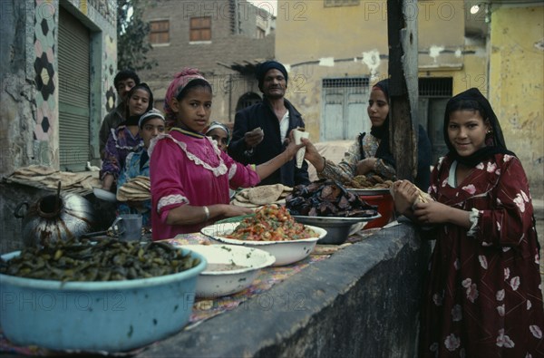 EGYPT, Cairo, Young woman stall holder selling prepared foods at market.